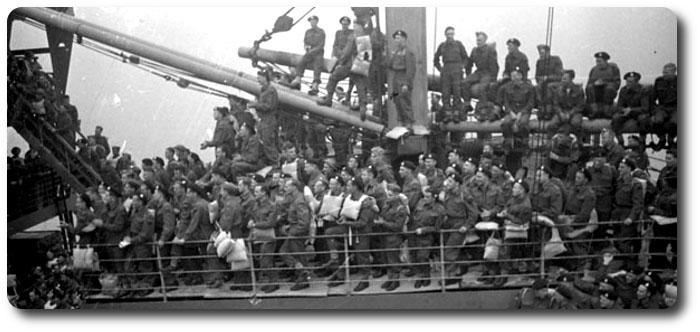Canadian Soldiers; Courage at Sea Topic: Canadian Army Canadian soldiers aboard a troopship arriving at Greenock, Scotland, 31 August 1942. Photographer: Laurie A.