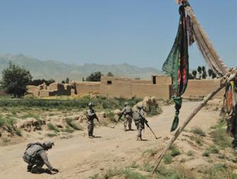 A C-IED team tries to keep the road safe for travel, probing carefully for unexploded bombs as it moves through a village in Logar Province. nate.