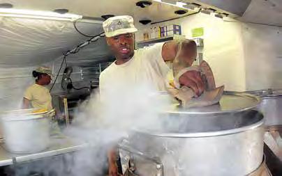 A sweaty Pfc. Ayron Bennett checks on a pot of boiling water. Temperatures can reach 100 degrees [Fahrenheit] in the cooking facilities. (PHOTO BY T. ANTHONY BELL, FORT LEE PUBLIC AFFAIRS.
