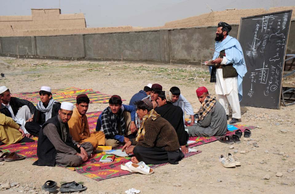 An Afghan local national teacher gives his students a class on arithmetic 22 March 2010, Karsai High School