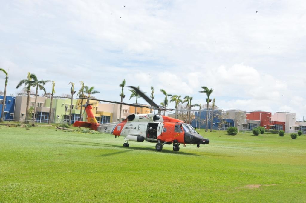A U.S. Coast Guard MH-60 Jayhawk helicopter crew lands at a soft ball field at a Coast Guard housing facility in Bayamon, Puerto Rico, Sept. 22, 2017.