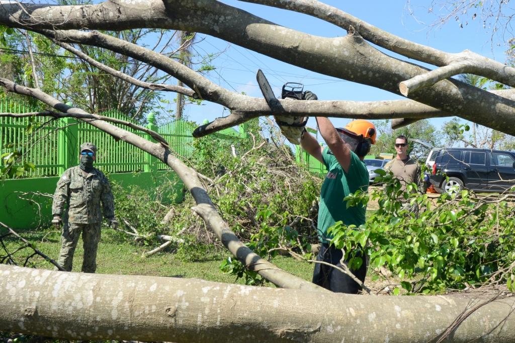 Coast Guard Petty Officer 2 nd Class Nick Rosner from Air Station Borinquen in Aguadilla, Puerto Rico, chainsaws a felled tree at Hogar de Niños Regazo de Paz in Aguadilla, Oct. 12, 2017.
