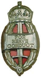 Crown over which appears a label with the words FOR VALUABLE SERVICE. This badge remained in use until the reform of British commendations in the 1990s.