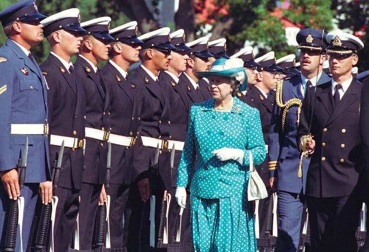 Queen Elizabeth II inspects the Guard of Honour, escorted by Lieutenant-Commander J.J.C.M.