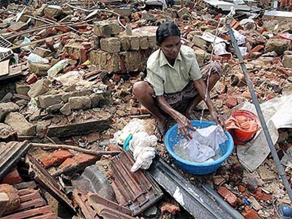 A woman does laundry in the rubble of her home devastated by the tsunami in Galle, southern Sri Lanka, on January 2, 2005/ UNHCR/N.Behring.