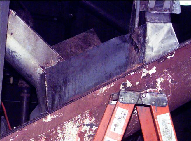 to the floor during the dismantling process. The auger in which the victim was entangled ran beneath where the conveyor and metal decking were removed as shown in Photo 1.