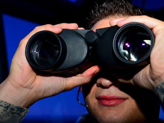 Senior Airman Romulo Montero, 6th Operations Support Squadron air traffic controller, looks through binoculars at a
