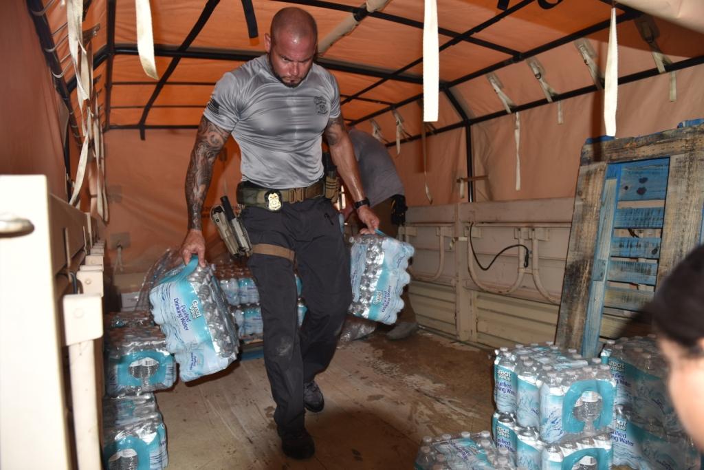 A member of Coast Guard Investigative Services offloads two cases of water at a hospital in Caguas, Puerto Rico, Oct. 18, 2017.