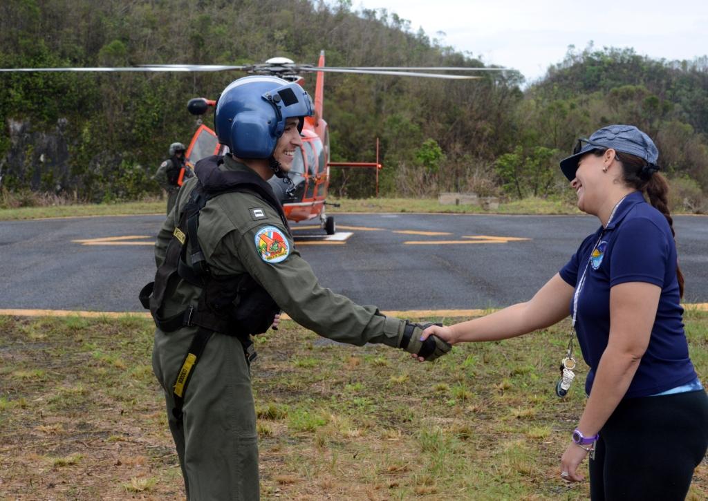 Lt. Brian Acuna, a pilot at Coast Guard Air Station Borinquen in Aguadilla, Puerto Rico, is greeted by a member of the Arecibo Observatory staff at the observatory in Arecibo, Puerto Rico, Oct.
