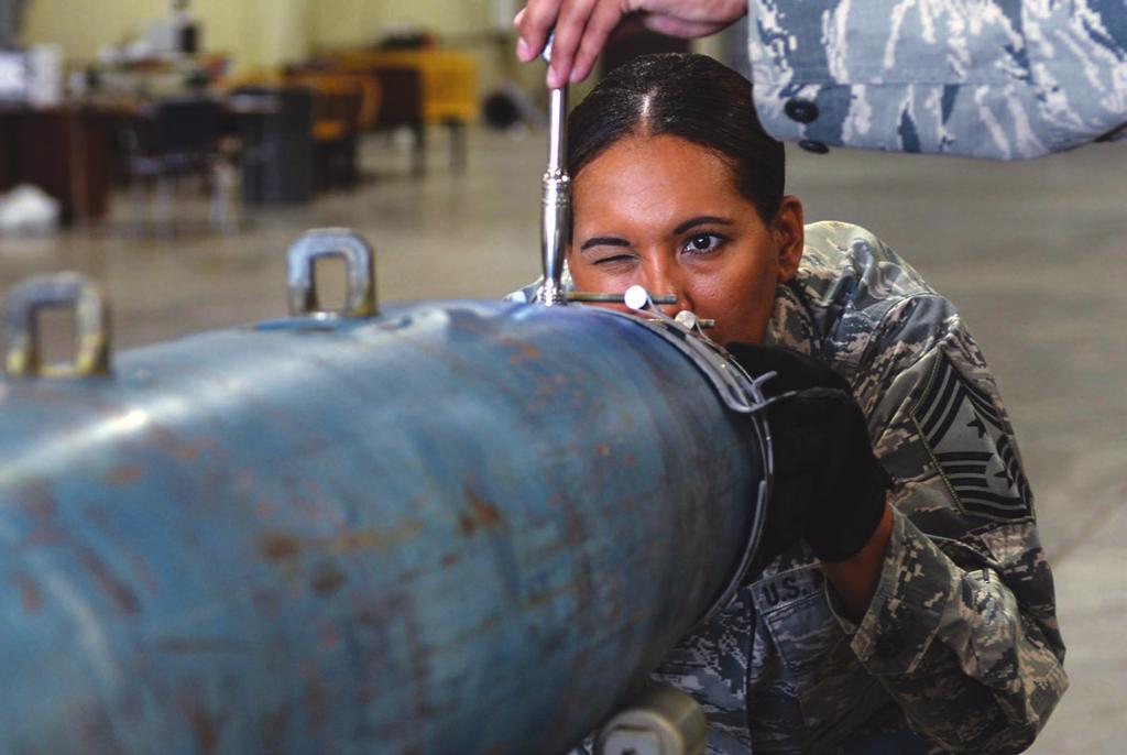 USAF photo by A1C Sadie Colbert Eagle Eye: CMSgt. Sonia Lee helps attach an aero surface strake on an inert GBU-38 v1 munition.