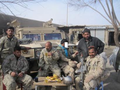 Ali having tea and cakes with the Afghan National Civil Order Police (ANCOP) in their compound in the village of Taloqan.