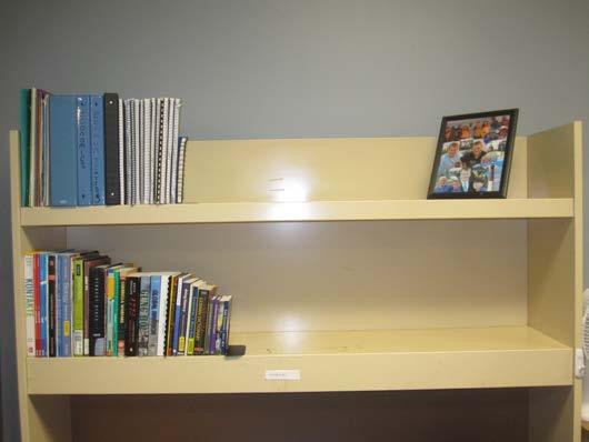 C. DESK Shelves organized in descending height order from left to right (flush with front edge) Top shelf: binders, spiral notebooks, oversized books, one picture Desk surface: clock radio, phone,