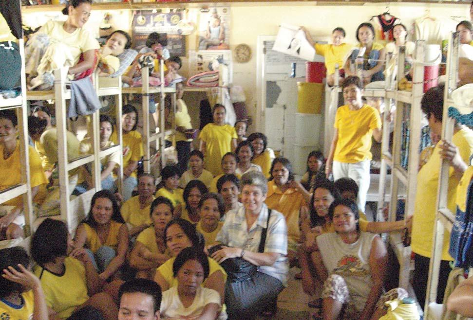 Sr. Liane Rainville sits on the floor among hundreds of Filipina detainees in their cramped sleeping quarters.