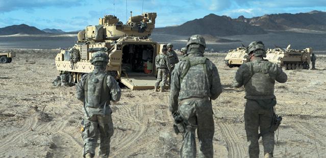 (DOD, EJ Hersom) Soldiers from the 2nd Brigade Combat Team, 1st Infantry Division from Fort Riley, Kan., gather near their Bradley Fighting Vehicles at the National Training in Fort Irwin, Calif.