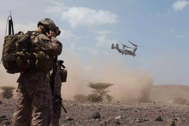 Conor Wood, a radio operator with Company I, Battalion Landing Team 3/8, 26th Marine Expeditionary Unit, communicates with his team while an MV-22
