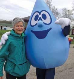 Above, she poses with Wally Water who teaches attendees about water issues and conservation.