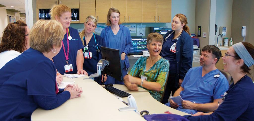 Chaplain Sue Motz, seated center right, huddles with C3 nurses, patient care assistants, and discharge planners to discuss spiritual distress and protocol for initiating follow-up support at Mercy