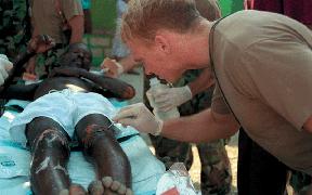 Organization and Command Relationships for Civil-Military Operations A corpsman examines the wounds of a Haitian man during Operation UPHOLD DEMOCRACY.