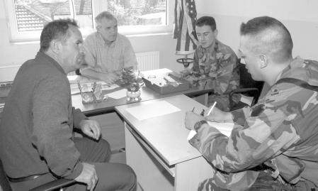 US Army Pennsylvania Guardsmen talk with a school principal in Gonji Livocto, Kosovo, to find out how many of the school s children are Serbian, 23 September 2003.