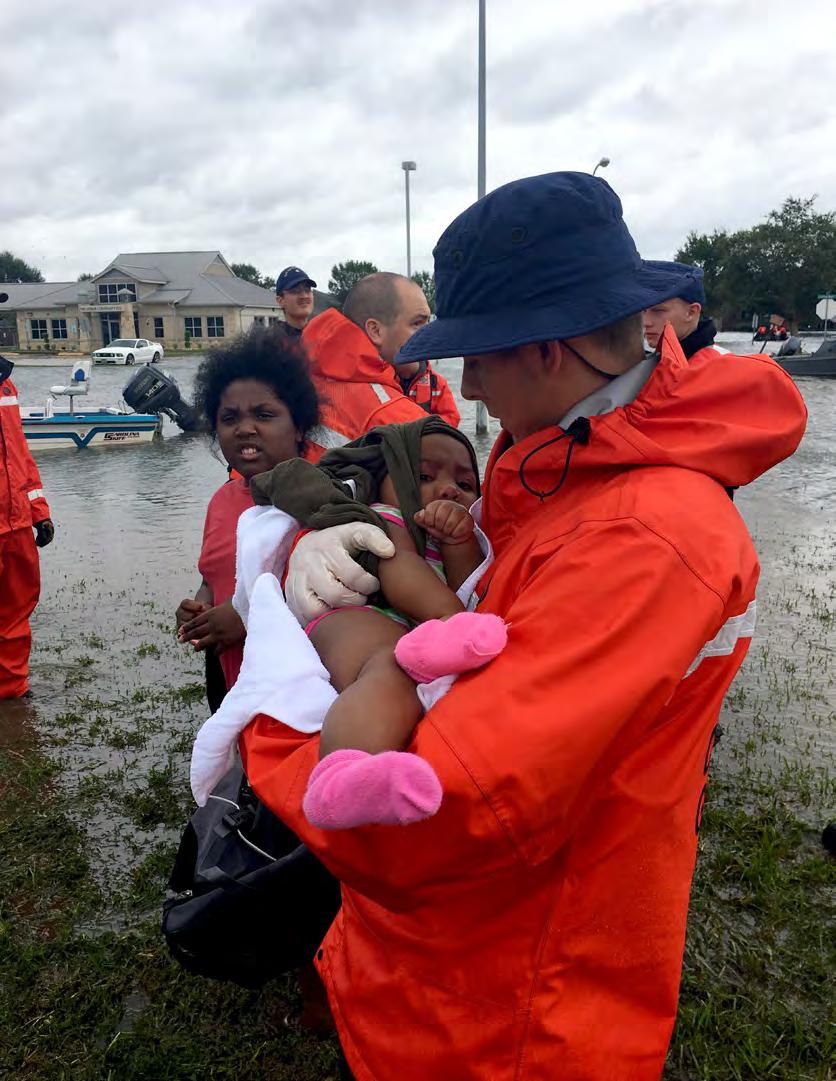 A Coast Guard member assigned to Maritime Safety and Security Team New Orleans, rescues a child in support of Hurricane Harvey relief efforts in Port