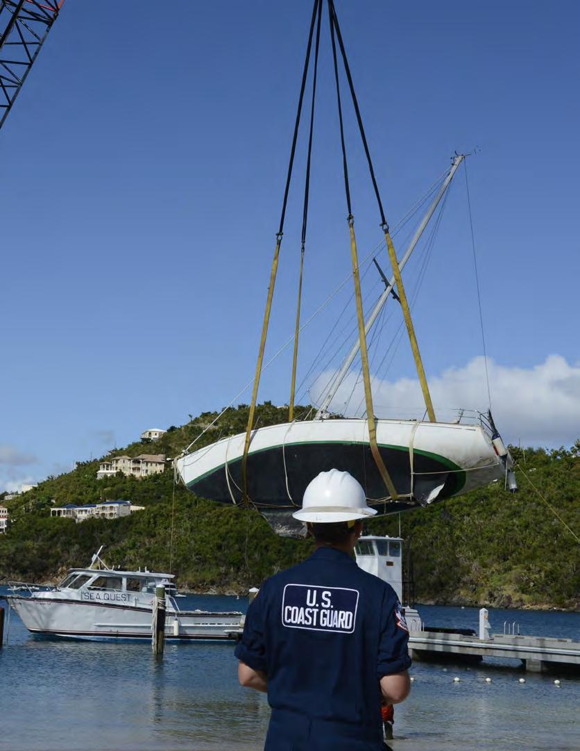 A Coast Guard member of the Pacific Strike Team, observes crane operations as they remove a sunken vessel from Great Cruz