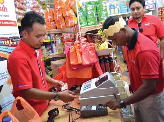 A Mah Meri recipient keys in his personalised 6-digit PIN when demonstrating the use of the MyKasih smartcard to purchase approved food