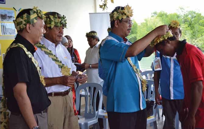 JAKOA Director-General YBhg Dato Haji Mohd Sani bin Mistam handing out the MyKasih smartcard to the Mah Meri food aid recipients of Pulau