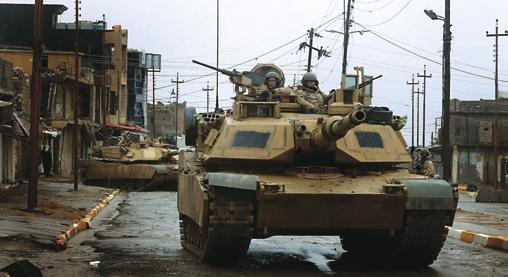 Crews and M1 Abrams tanks attached to the 3rd ACR, also known as the Brave Rifles, maneuver in the streets as they conduct a combat patrol in Tal Afar in February 2005.