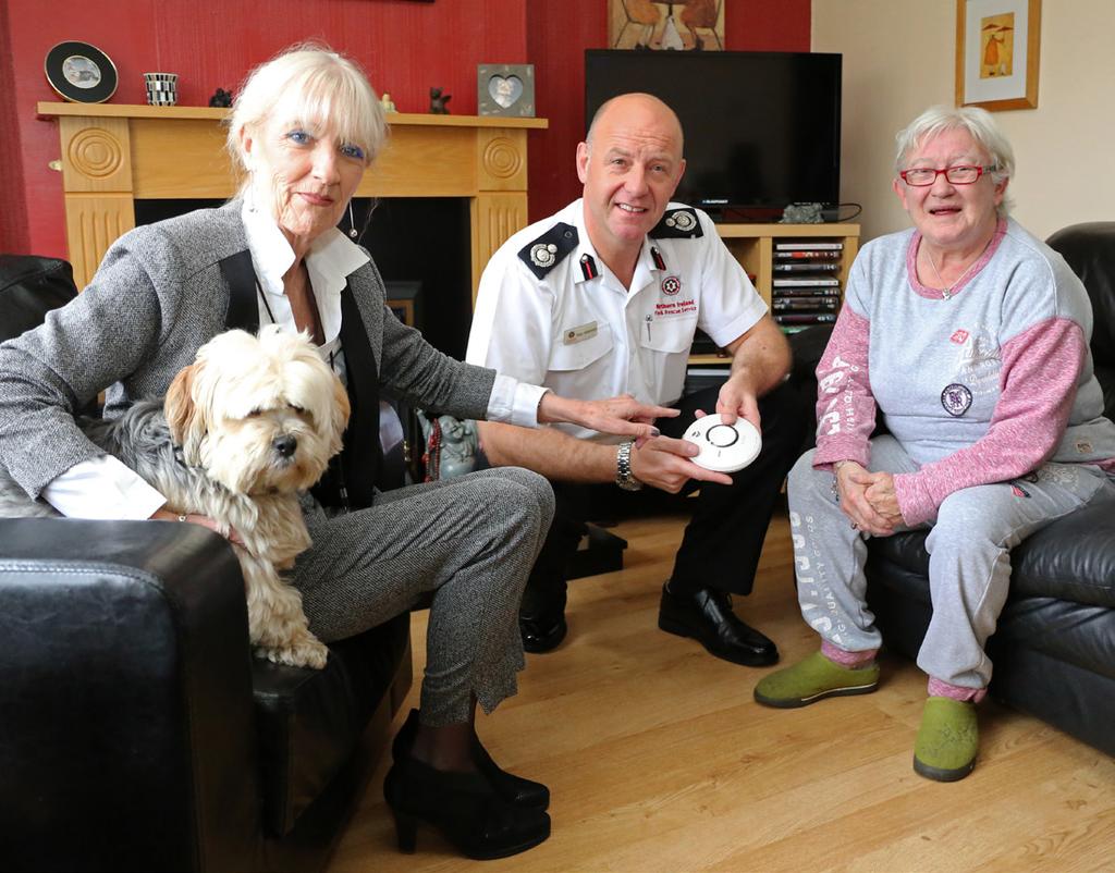 Carmel McKinney, NIFRS Chair, and ACO Alan Walmsley visit Angie McManus and Jimmy, the dog, in her Belfast home NIFRS will target resources to deliver positive outcomes for those people most at risk
