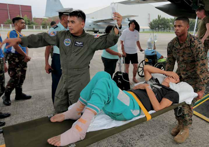 Marines carry injured Filipino woman on stretcher for medical attention at Villamor Air Base, Philippines, November 11, 2013 (DOD/Caleb Hoover) gaps, and potential opportunities across the full
