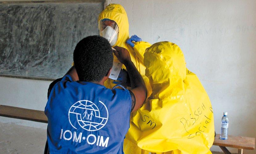 AS PART OF THE EBOLA RESPONSE IN SIERRA LEONE, IOM S LEAD TRAINER, GLADYS MBABAZI, ADJUSTS A