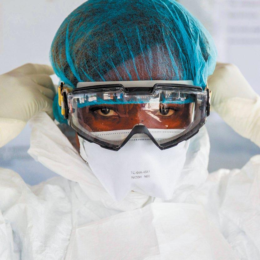 22 A NURSE PUTS ON HER PERSONAL PROTECTIVE EQUIPMENT (PPE) BEFORE HEADING TO THE RED ZONE OF AN
