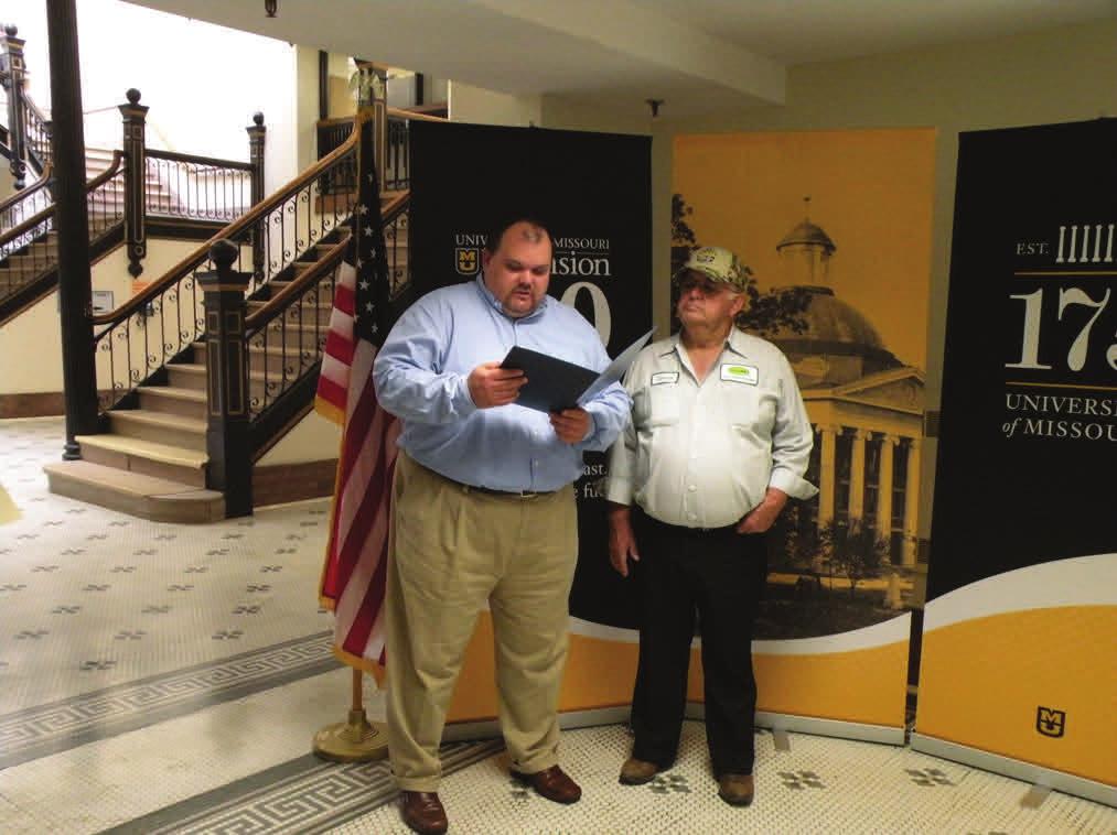 Mo-06 (right) present centennial proclamations to Donnie Miller, vice chair, Buchanan County Extension Council.