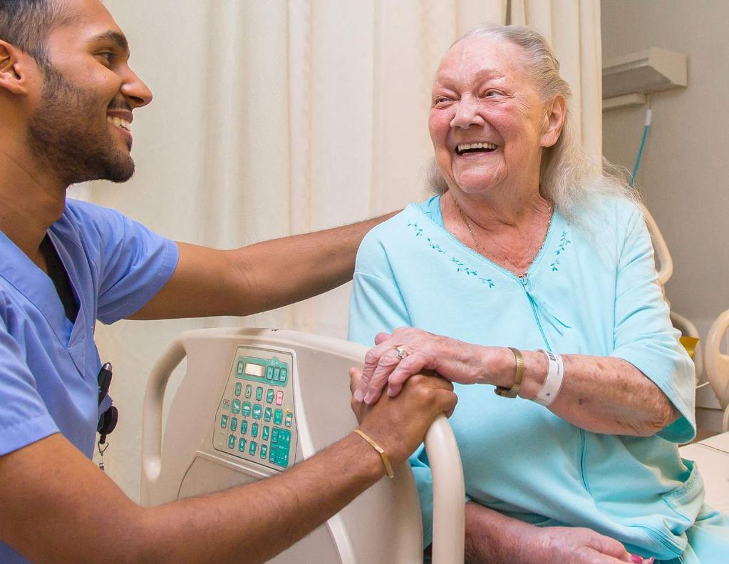 Registered Nurse Deny Thomas lends a helping hand and a smile to patient Joyce MacKay at our