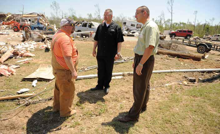STATE SERVICES AND DISASTER RELIEF Above: DAV representatives survey tornado damage with a veteran in Mayflower, Ark., in May 2014.