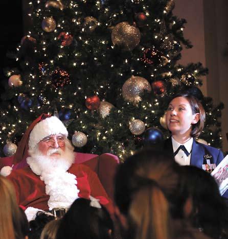Air Force Band of the West Concert Band vocalist, reads the story of Rudolph the Red Nosed Reindeer with Santa Claus to children from the audience during