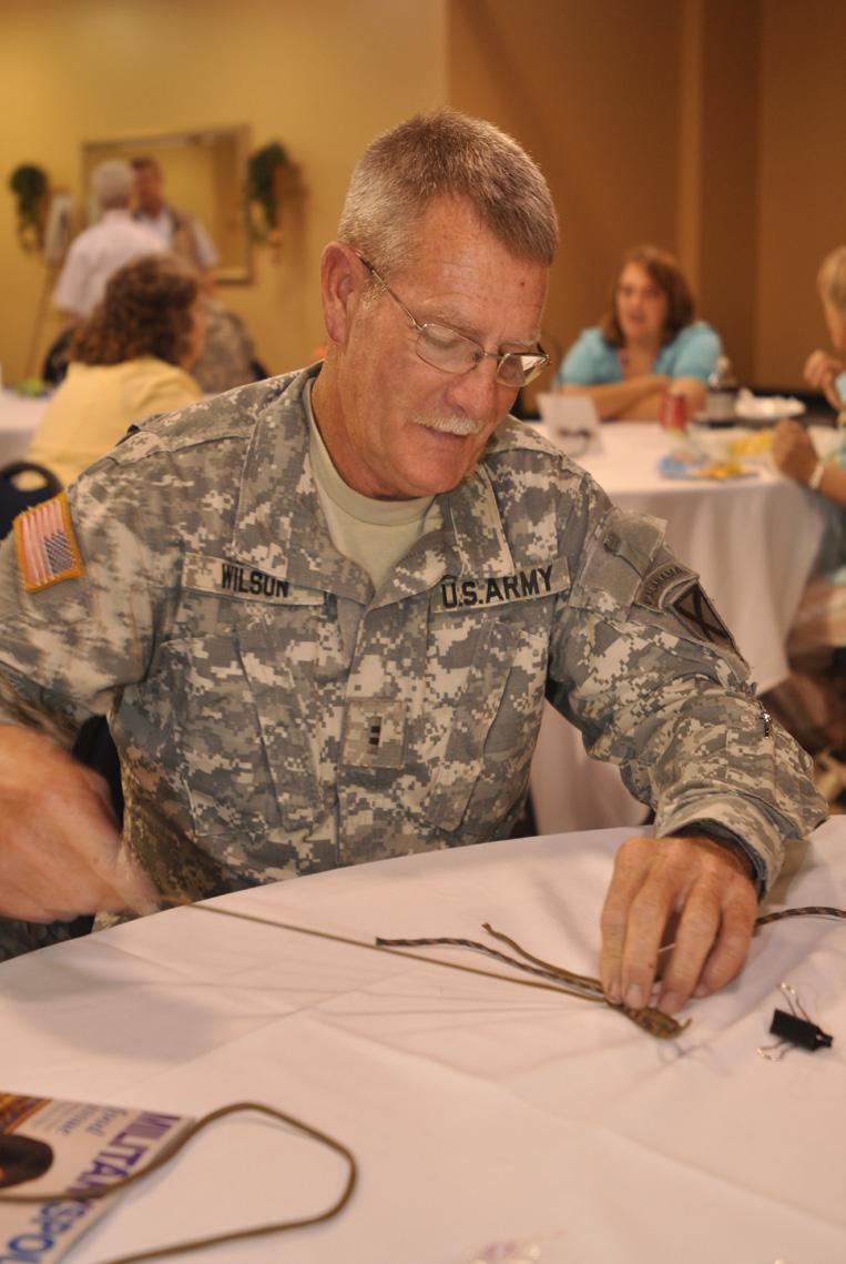 Chief Warrant Officer 2 Joseph Wilson, FSC 1-167th Infantry, makes a paracord bracelet during the State Family Programs Volunteer Workshop