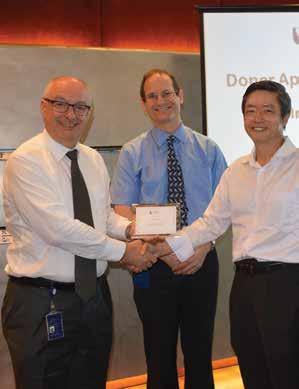 (Left to right) SMU President Professor Arnoud De Meyer and Dean of SMU School of Information Systems Professor Steven Miller presenting a memento to Mr Ng Kai Wa.