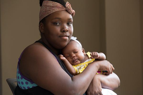 A mother holds her newborn at her local health center.