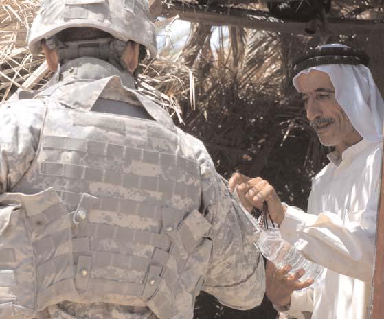 Paul Funk II, 1st Brigade Combat Team, 1st Cavalry Division commander, greets Abu Azzam, a leader of the Nasr Wa Salam volunteer center Aug. 14.