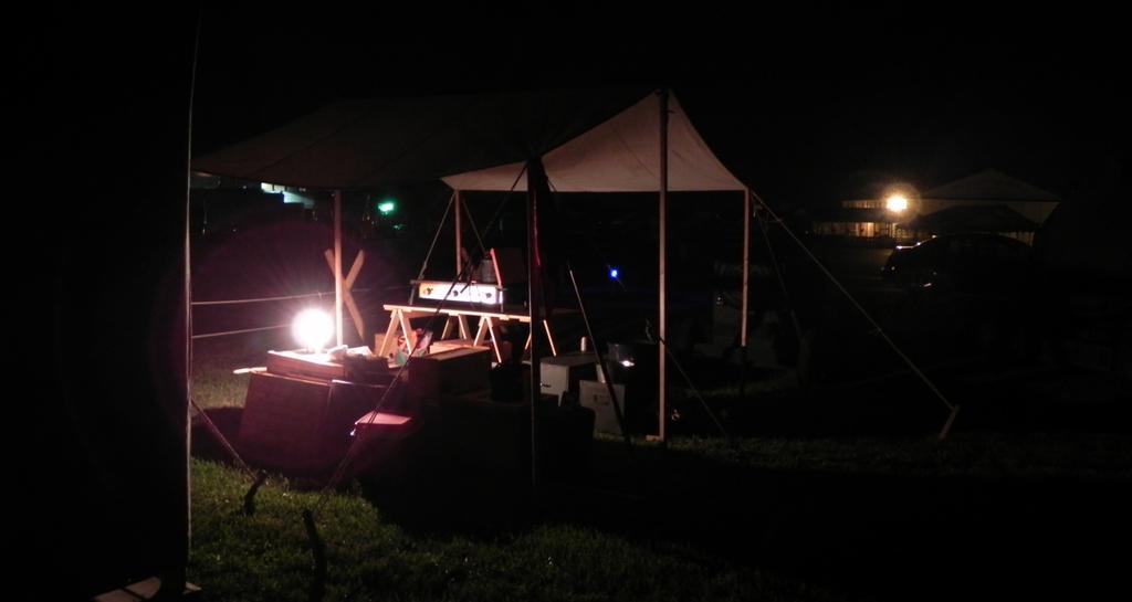Here, part of the encampment is lit by lantern light