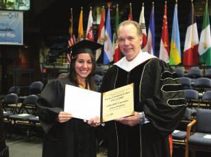President Laurence Spraggs presents Student Trustee Vicki Papastrat with a ceremonial millionth degree for the entire graduating class.
