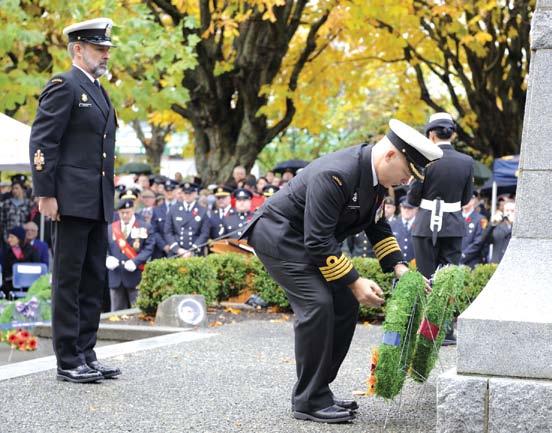 Photo: PO1 Mike Mitchell Ordinary Seaman Curtis Conarroe from HMCS Malahat lays a poppy at the gravesite of Commander Rowland