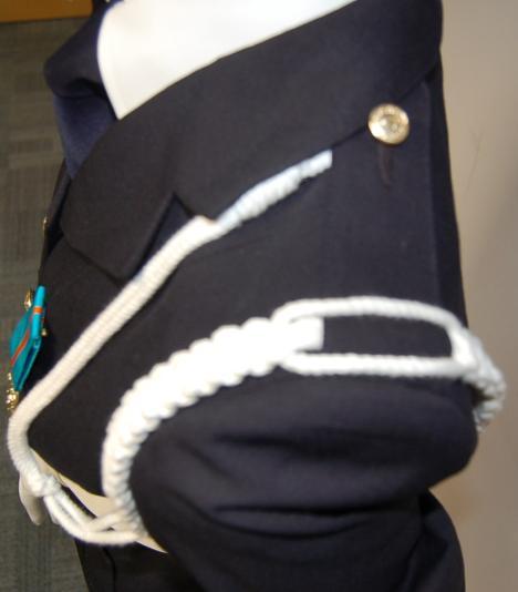 left plain. The outer two strands shall be worn on the top surface of the epaulette and the centre pair on the lower surface.