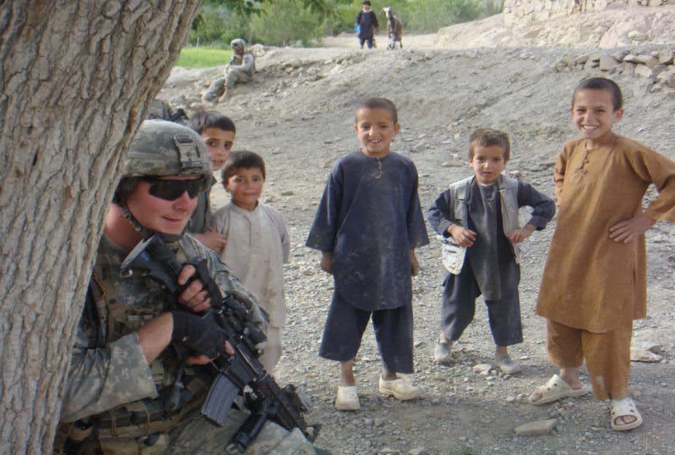 U.S. Army Soldier from 3rd Platoon, Chosen Company, 2nd Battalion, 503rd Infantry, 173rd Airborne, pulls security while the local Afghan kids
