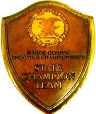 ) 25 Medallion shaped wooden award; black sides; blue and white Kamehameha Schools seal at top Kamehameha Schools Bishop