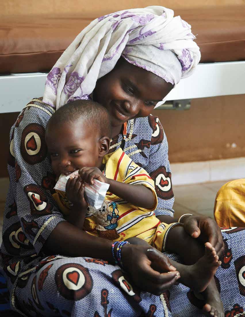 Health Coordinator Bintou assists Mariam in feeding plumpynut to her son, Al-Matar, during a feed test at the community health centre in Gao, Mali on April 2, 2014.
