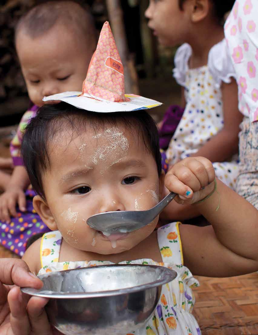 A child eating rice porridge with a micronutrient sprinkle supplement added.