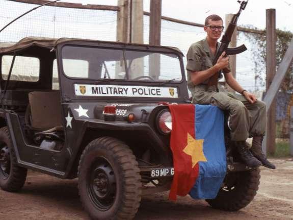 Evidence of the Viet Cong In this picture, Eric is posing with an AK-47 rifle and a Viet Cong flag.