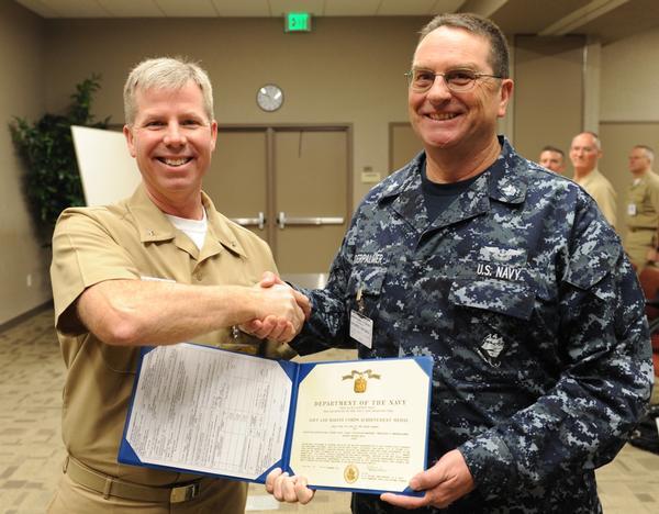 Rear Adm. Kirby Miller, left, presents a Navy and Marine Corps Commendation Medal to Cmdr. Donald Brockett. (U.S. Navy photo) Rear Adm.